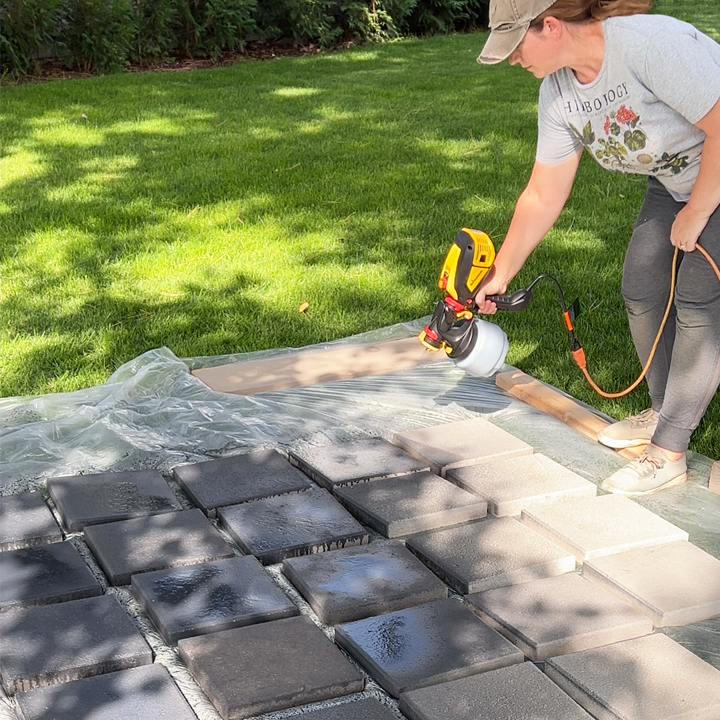 spraying stain on concrete pavers